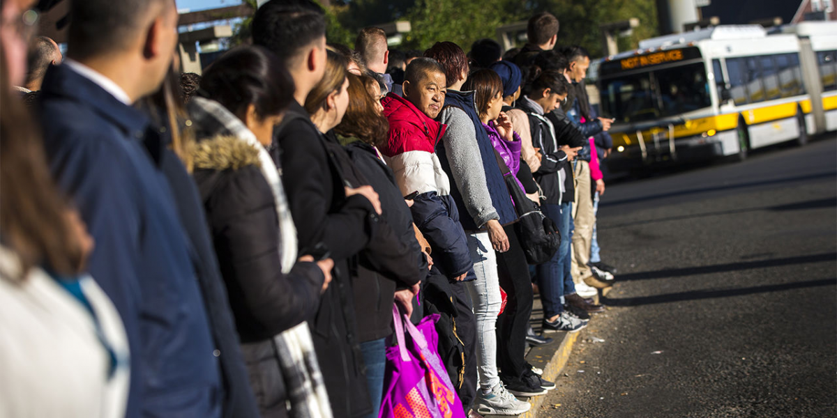 commuters waiting in line for bus