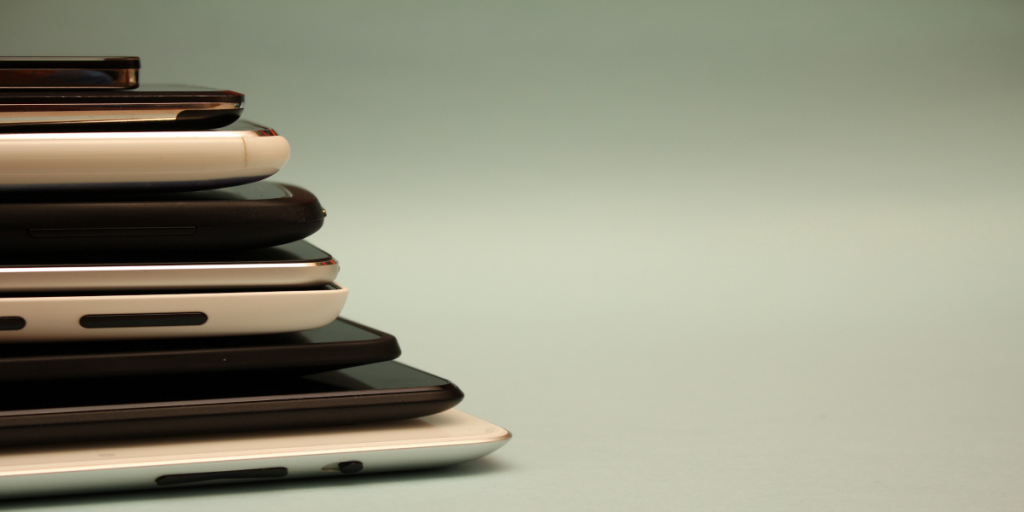 stacked phones, laptops, and tablets