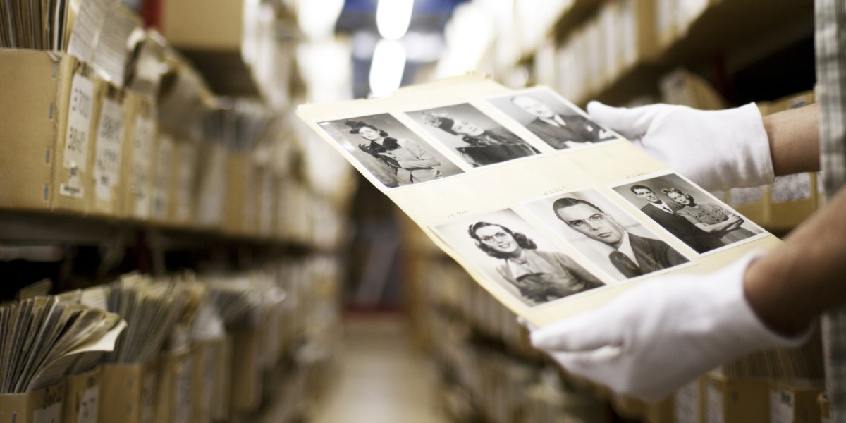 A photo of a man handling physical photos at the Hulton Archives