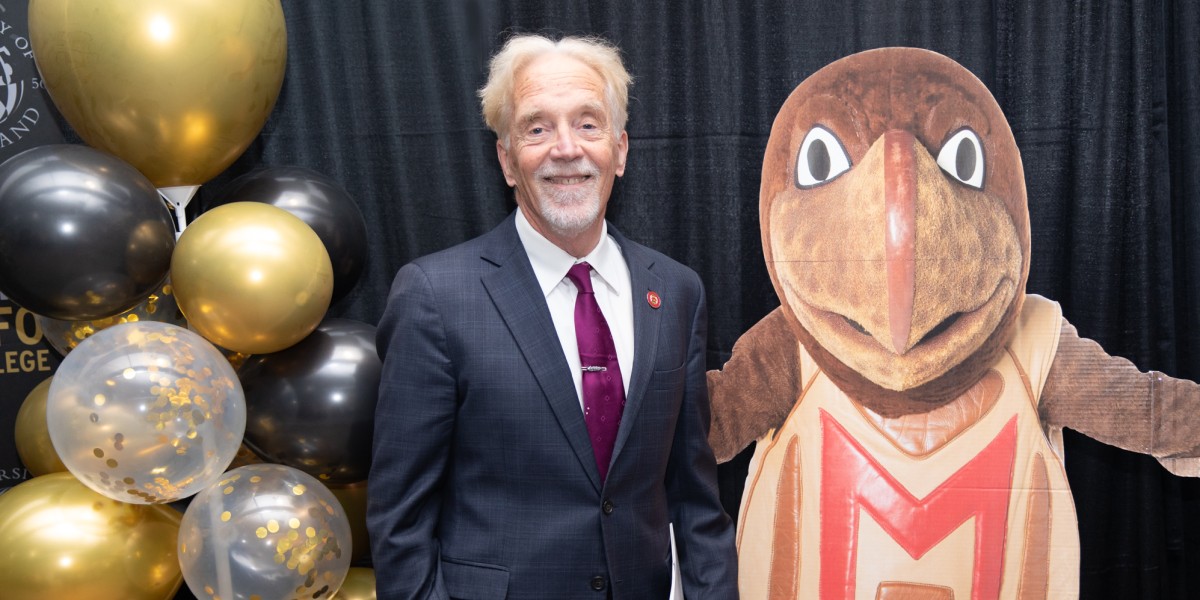 Photo of Keith Marzullo posing with UMD mascot testudo