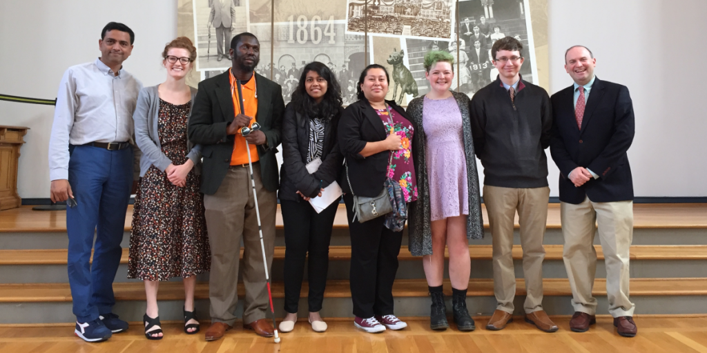 photo of eight people standing next to each other smiling at the camera