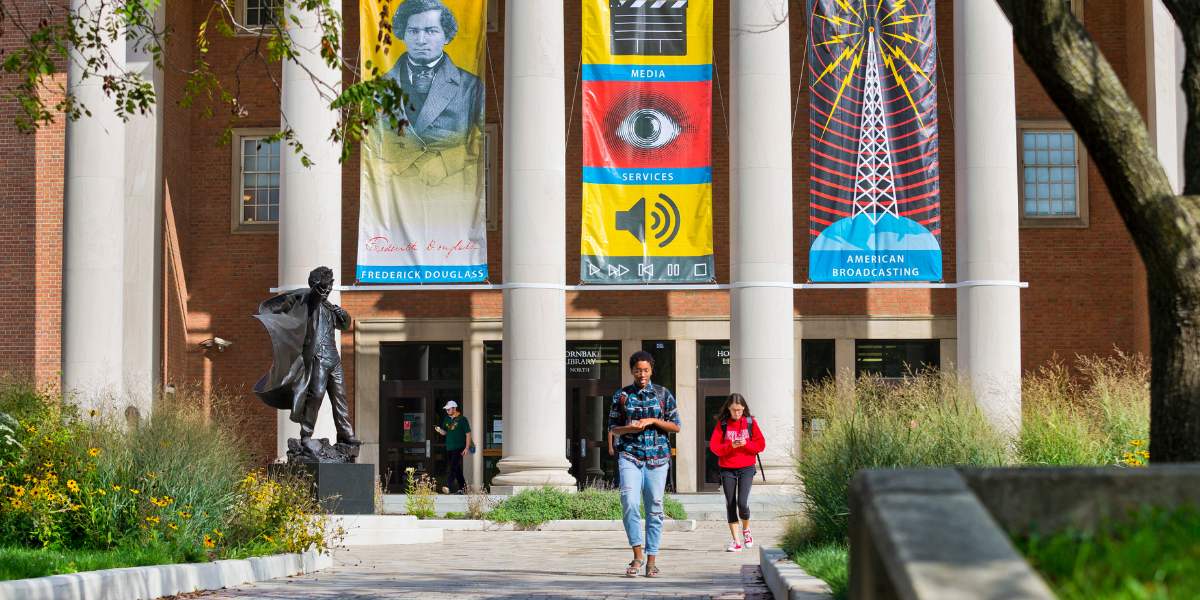 Students walking outside of Hornbake Library on a sunny day