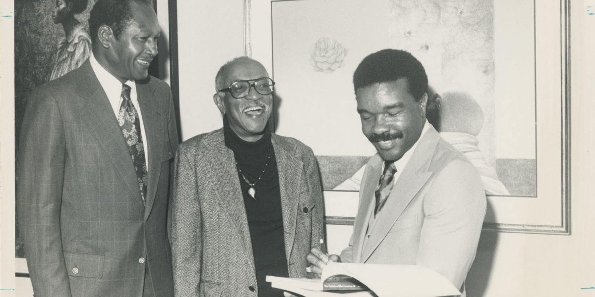 black and white photo of three men smiling