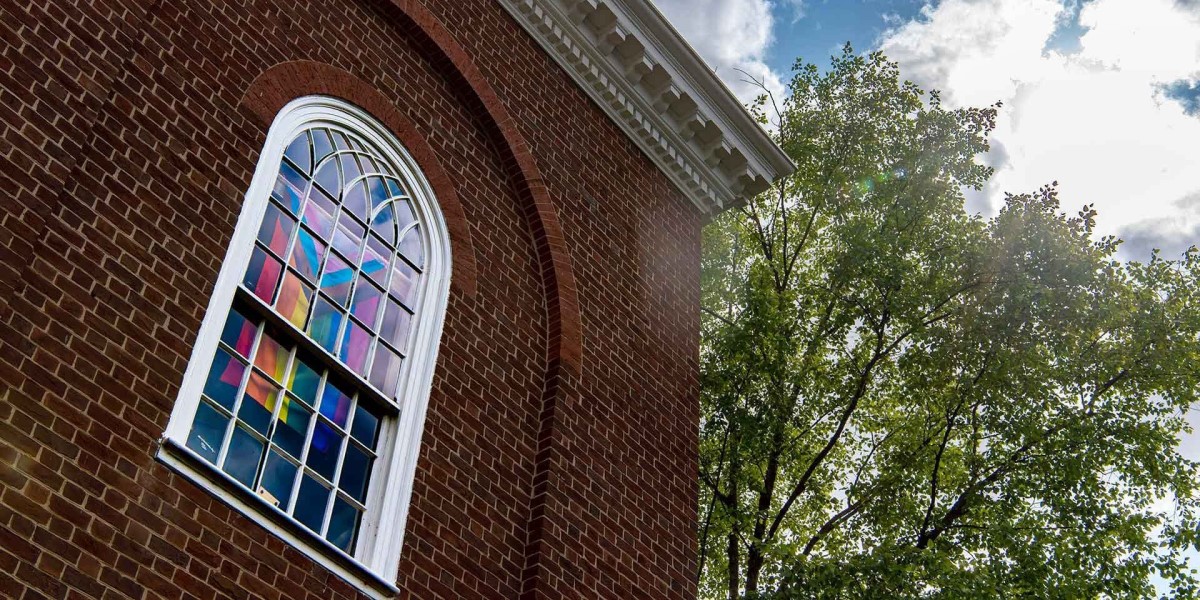 Photo of a UMD building with a pride flag hanging in a window