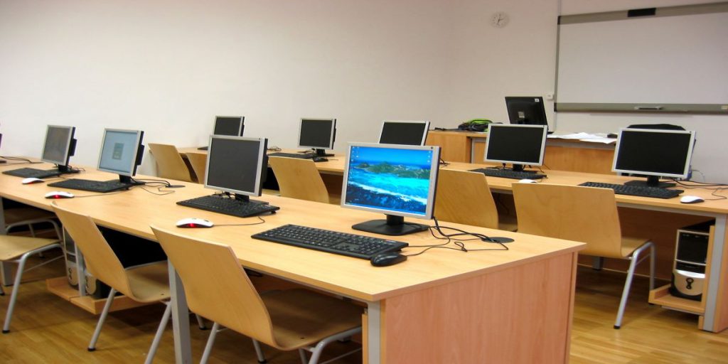 room filled with long desks and rows of computers