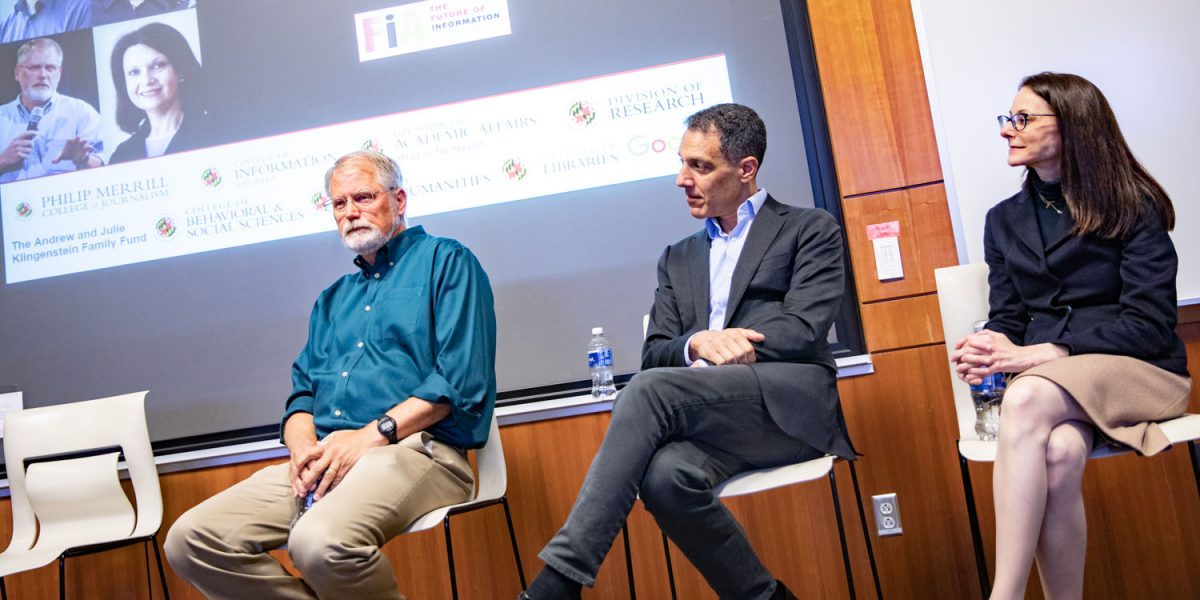 three people sitting in chairs in front of a projector