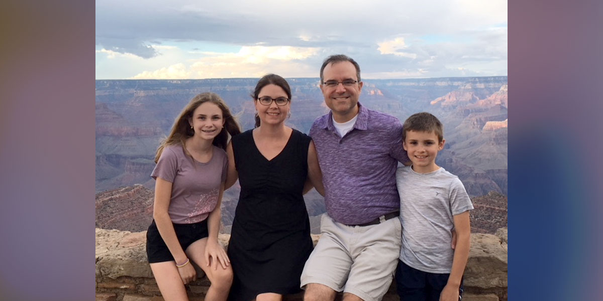 family smiling with mountains behind them