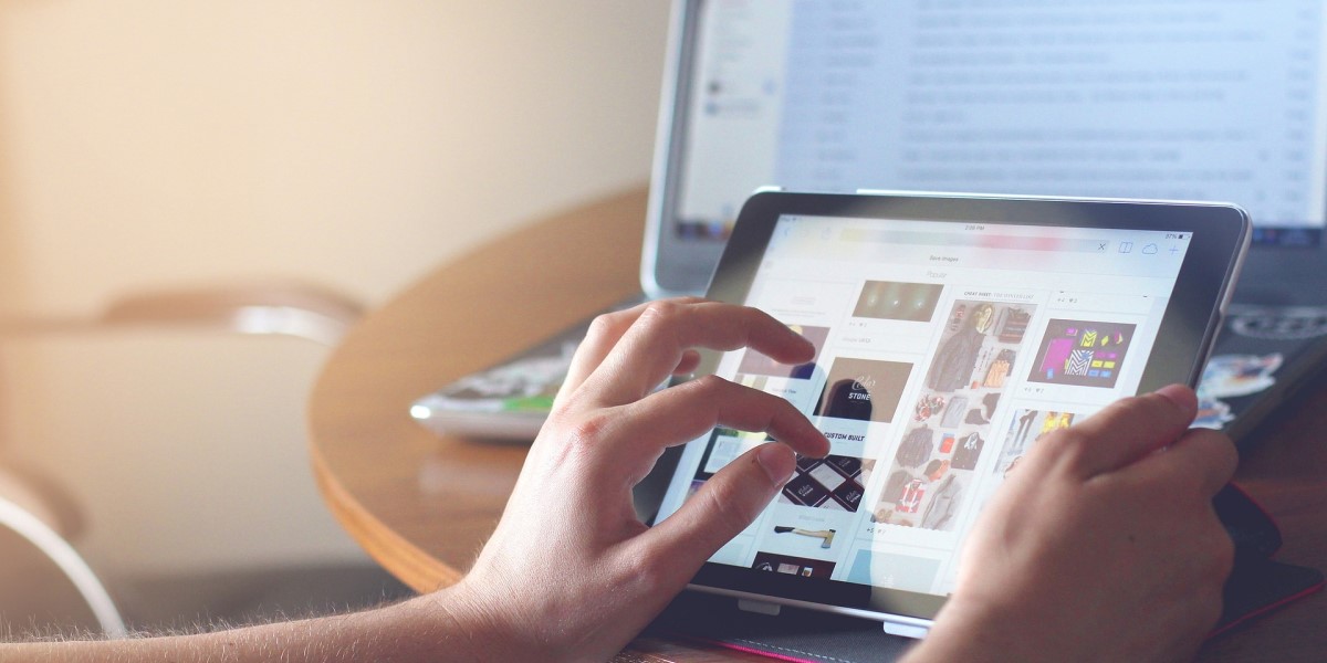 Photo of a person using a computer and tablet.