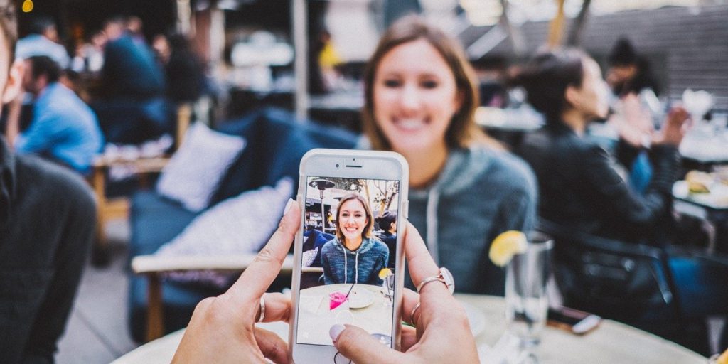 person taking a photo of another person using a smartphone