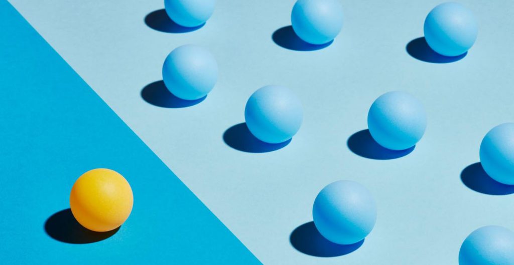 one yellow ball next to rows of blue balls